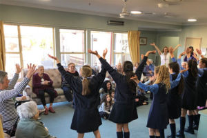 Students performing to an elderly audience